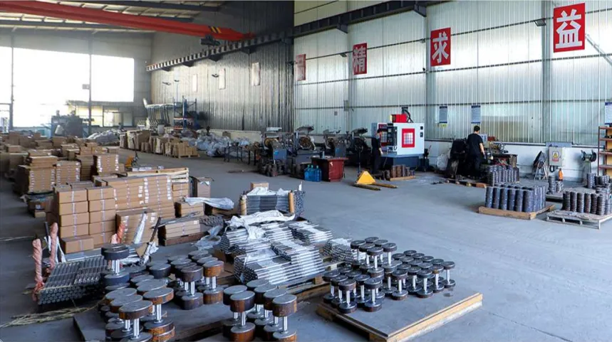 Production floor with dumbbells and weight plates awaiting inspection